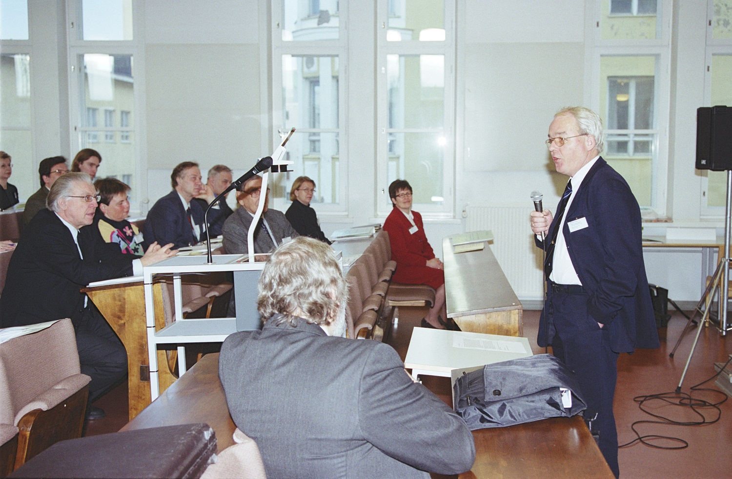 Marcel Van den Broecke seisoo oikealla pitämässä seminaaripuhetta.