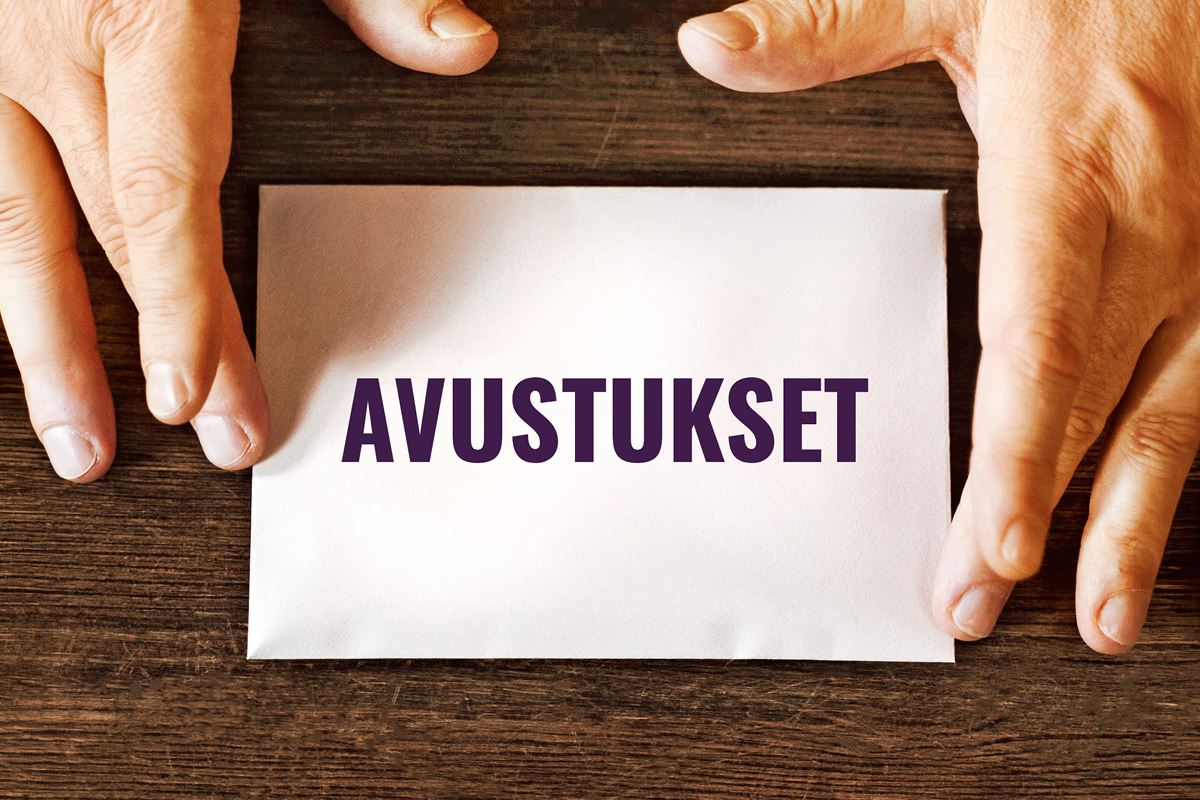 Ett kuvert med texten avustukset mellan två händer.