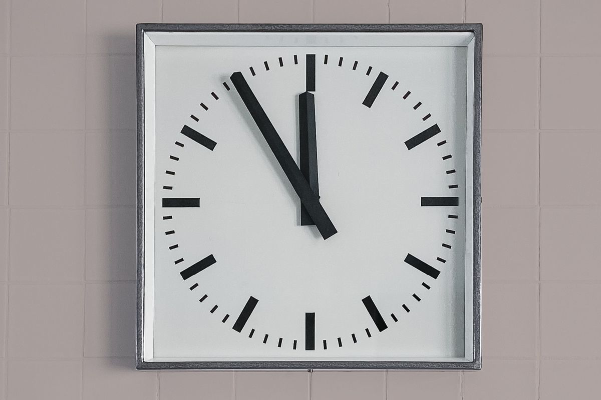 Seinäkello, joka näyttää ajan klo 11:55.
