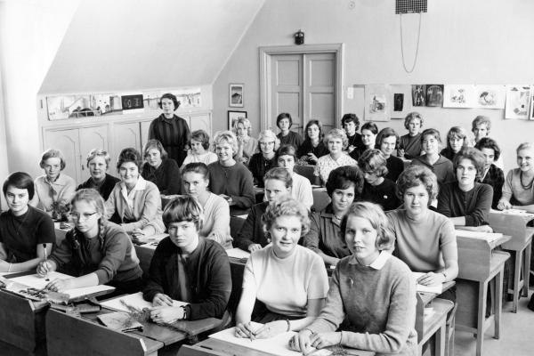 Nuoria naisoletettuja vanhanaikaisten pulpettien ääressä.